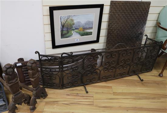 A three fold wire mesh spark guard, a pair of 17th century style iron fire dogs and a cast iron fire back guard W.141cm